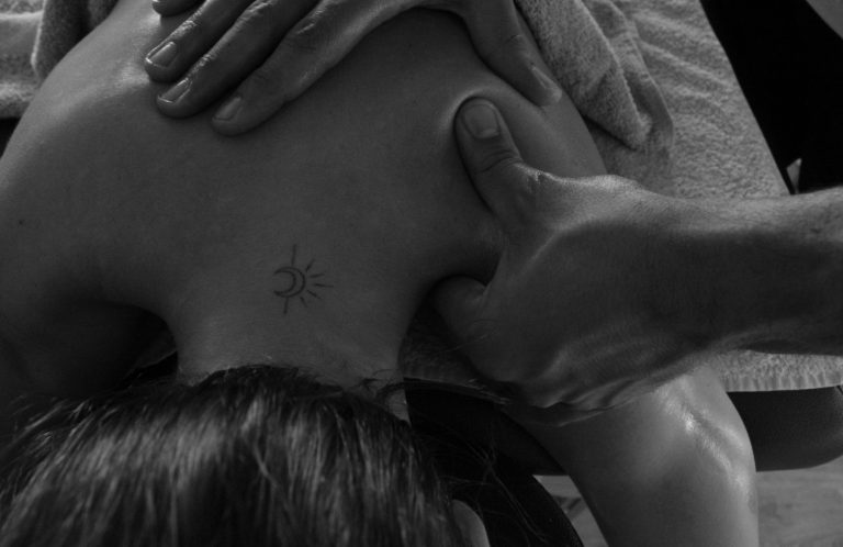 A person receiving a massage, focusing on hands and back.